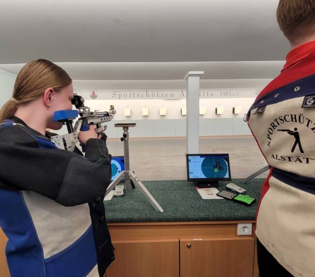Schützin zielt mit Gewähr auf Zielscheibe